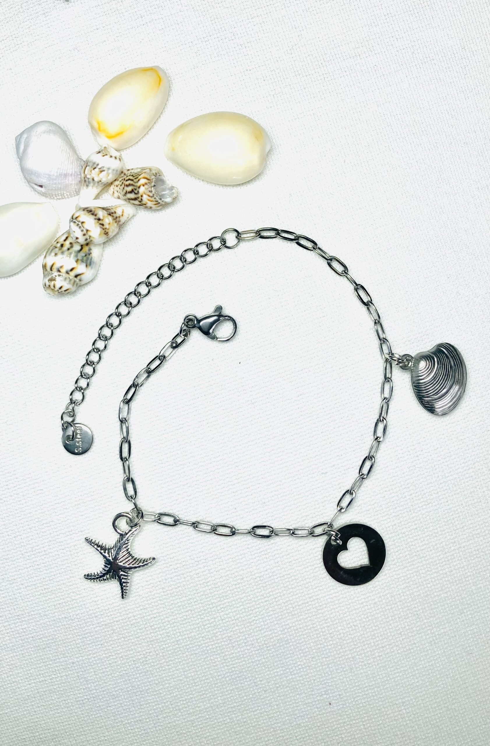 Zilver RVS armbandje met een zeester, hartje en schelp als bedeltje