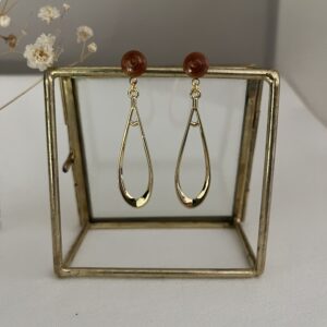 Lange slanke oorbellen van metaal aan een bronskleurige RVS oorsteker