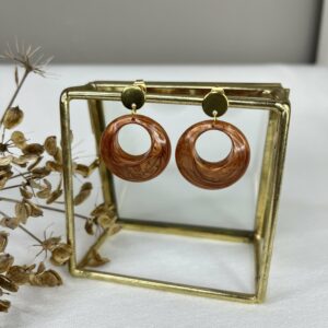 Mooie roestbruine resin oorbellen in een vloeiende ronde vorm