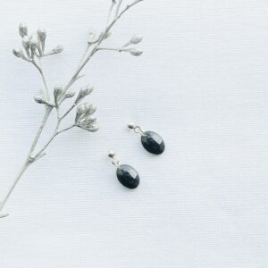 Mini ovale oorbellen van zwarte resin aan zilveren RVS oorknopjes