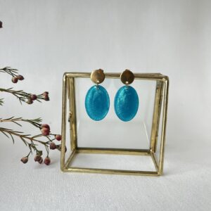 Ovale oorbellen in petrol resin met gouden RVS oorstekers