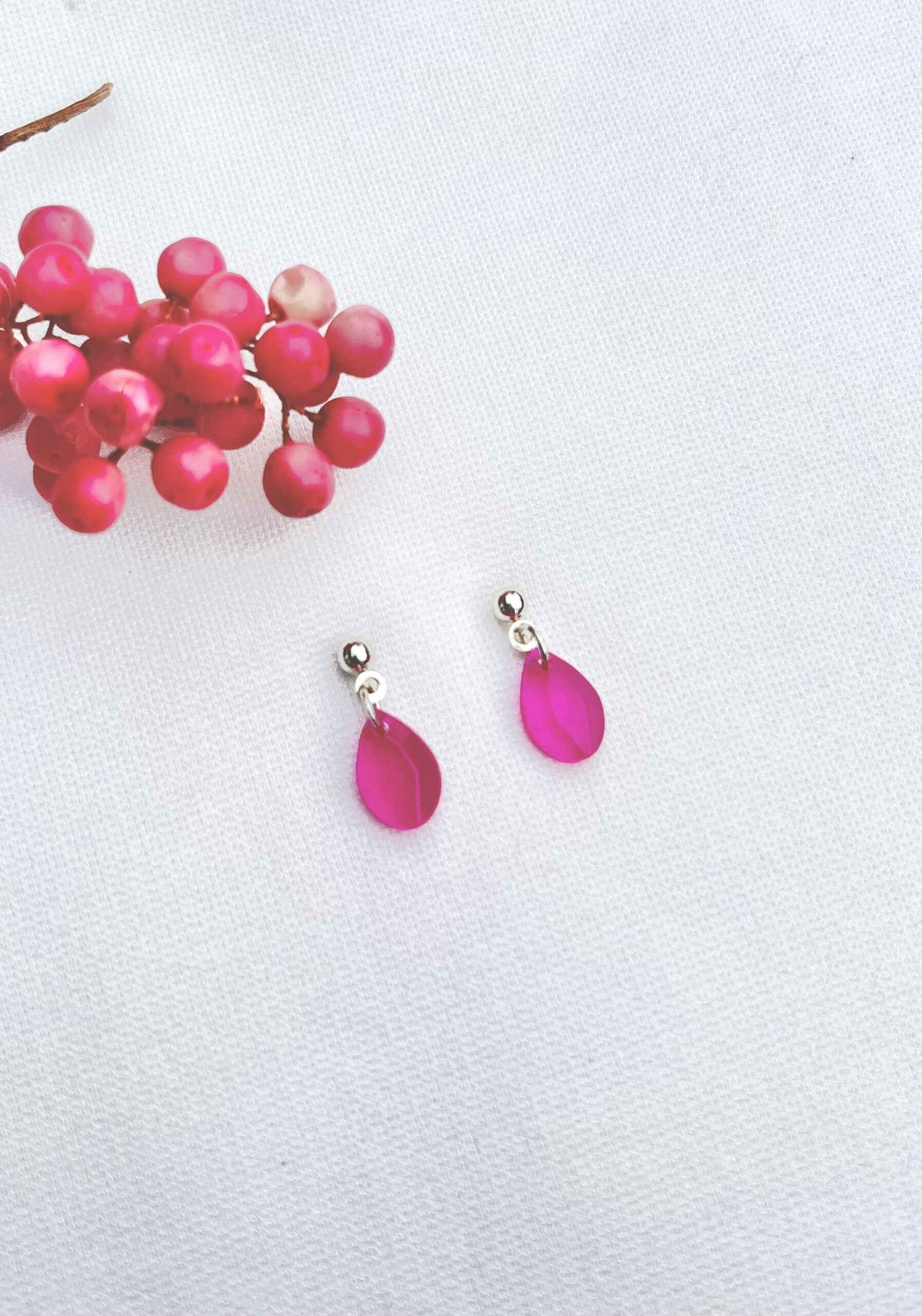 Mini druppel oorbellen van resin in een vrolijke fuchsia roze kleur met RVS zilveren oorknopjes