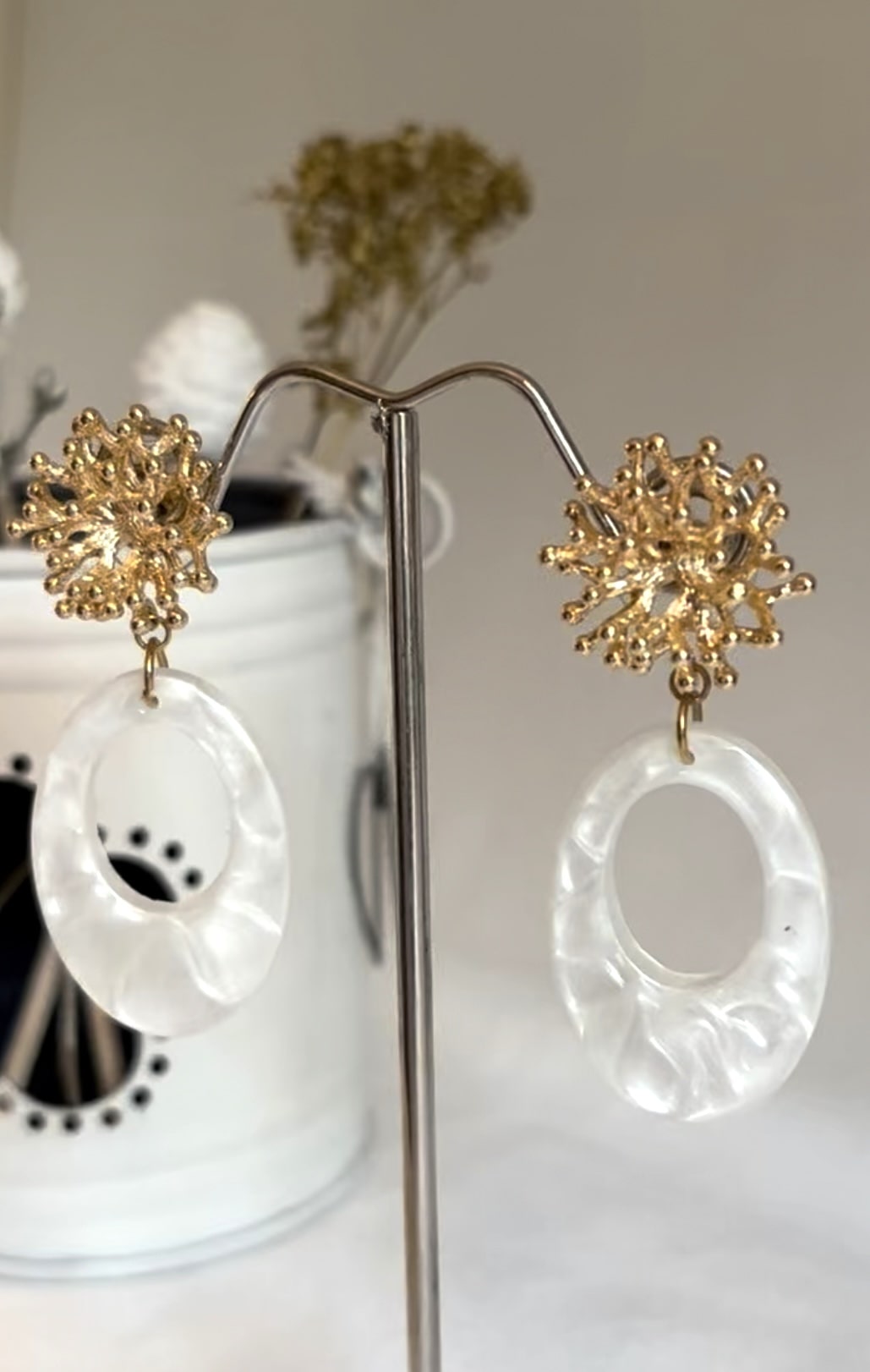 Ovale oorbellen van resin van een mooie witte parelmoer kleur aan RVS gouden koraal stekers