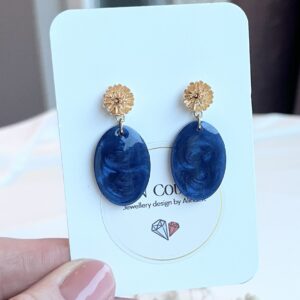 Ovale blauwe oorbellen van resin aan bloemen RVS oorstekers